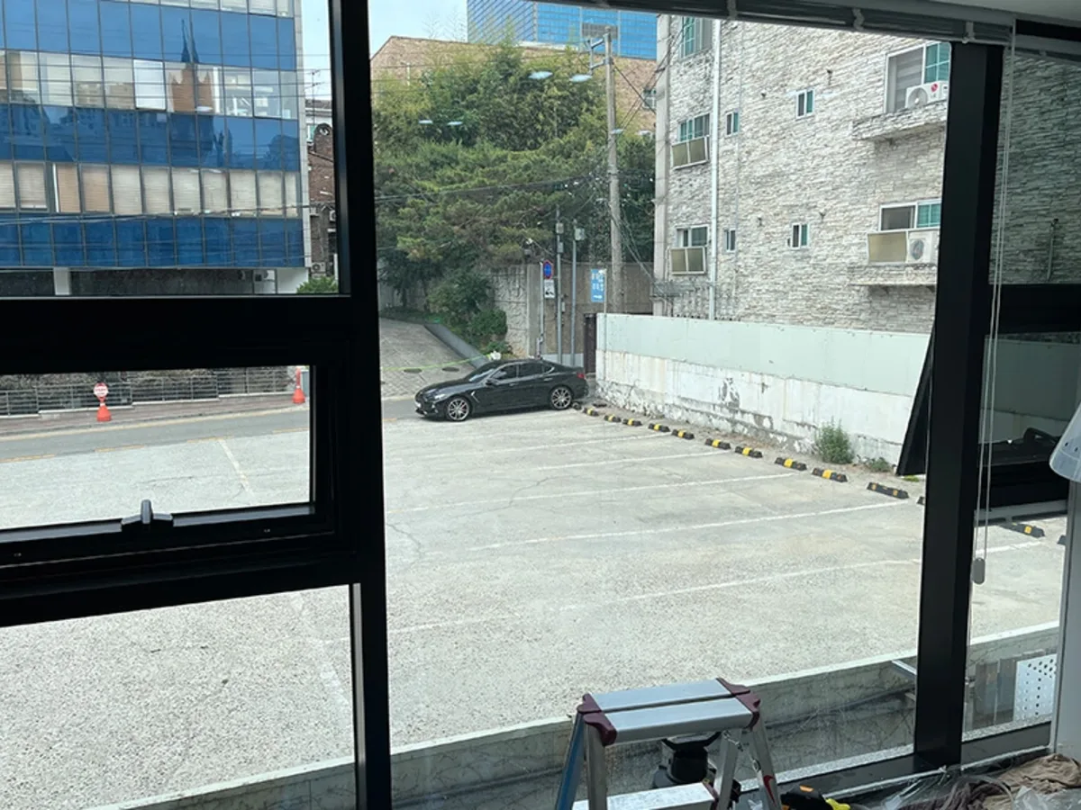 동물병원 창밖으로 주차장과 사다리가 놓인 작업 준비 중인 시공 전 사진