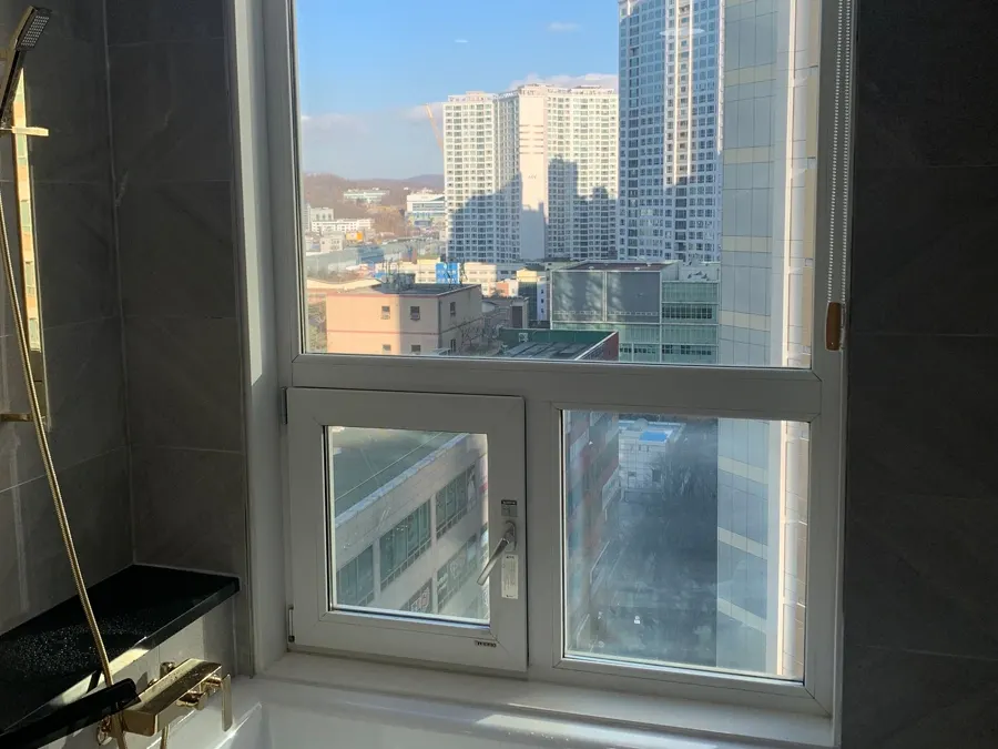 발코니 확장형 거실 창밖으로 도심 풍경이 보이는 시공 전 사진
