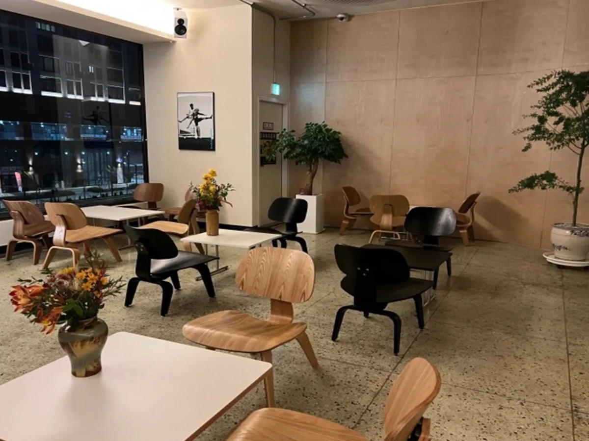 원목 테이블과 화분이 놓인 카페 홀 통유리창 밖으로 도심 야경이 보이는 시공 전 사진