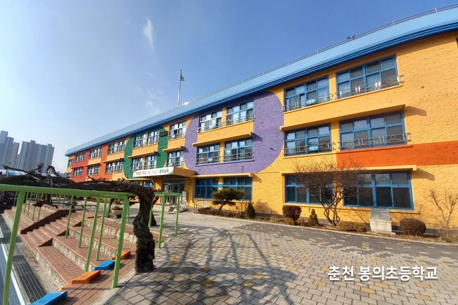 파란색과 노란색 포인트가 있는 초등학교 건물 외벽 사진