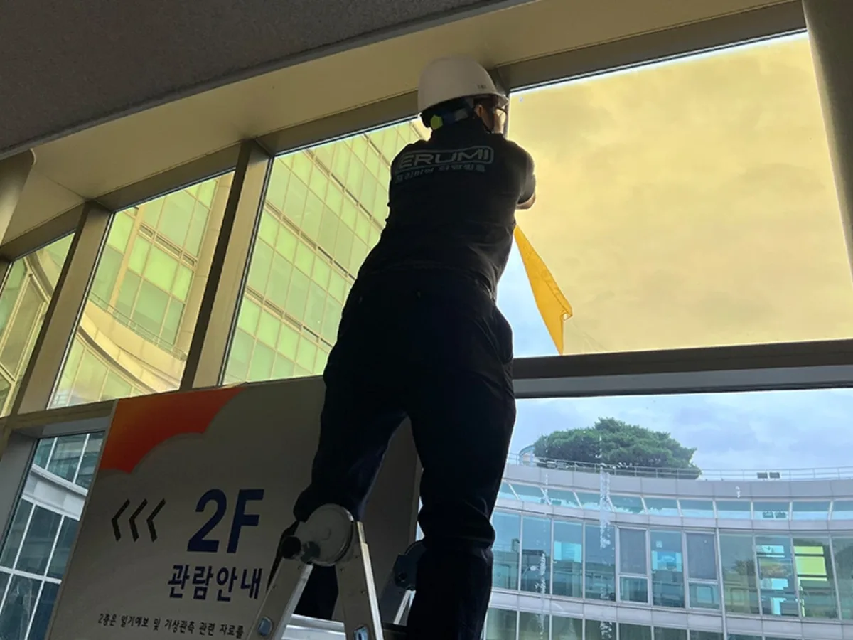 투명 유리창에 필름을 대어 반사되는 정도를 확인하는 시공 과정 사진