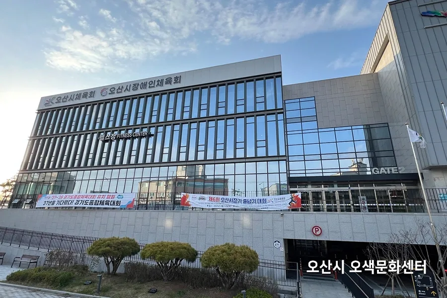문화센터 건물 외벽과 소나무가 심긴 화단이 보이는 사진