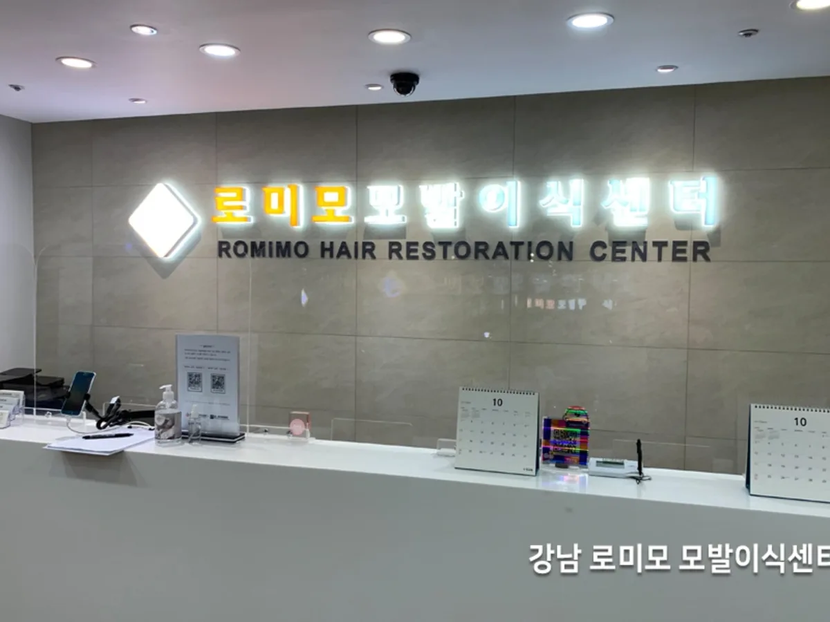 매장 안내 데스크 뒤편 벽면 간판 조명이 켜진 시공 전 사진