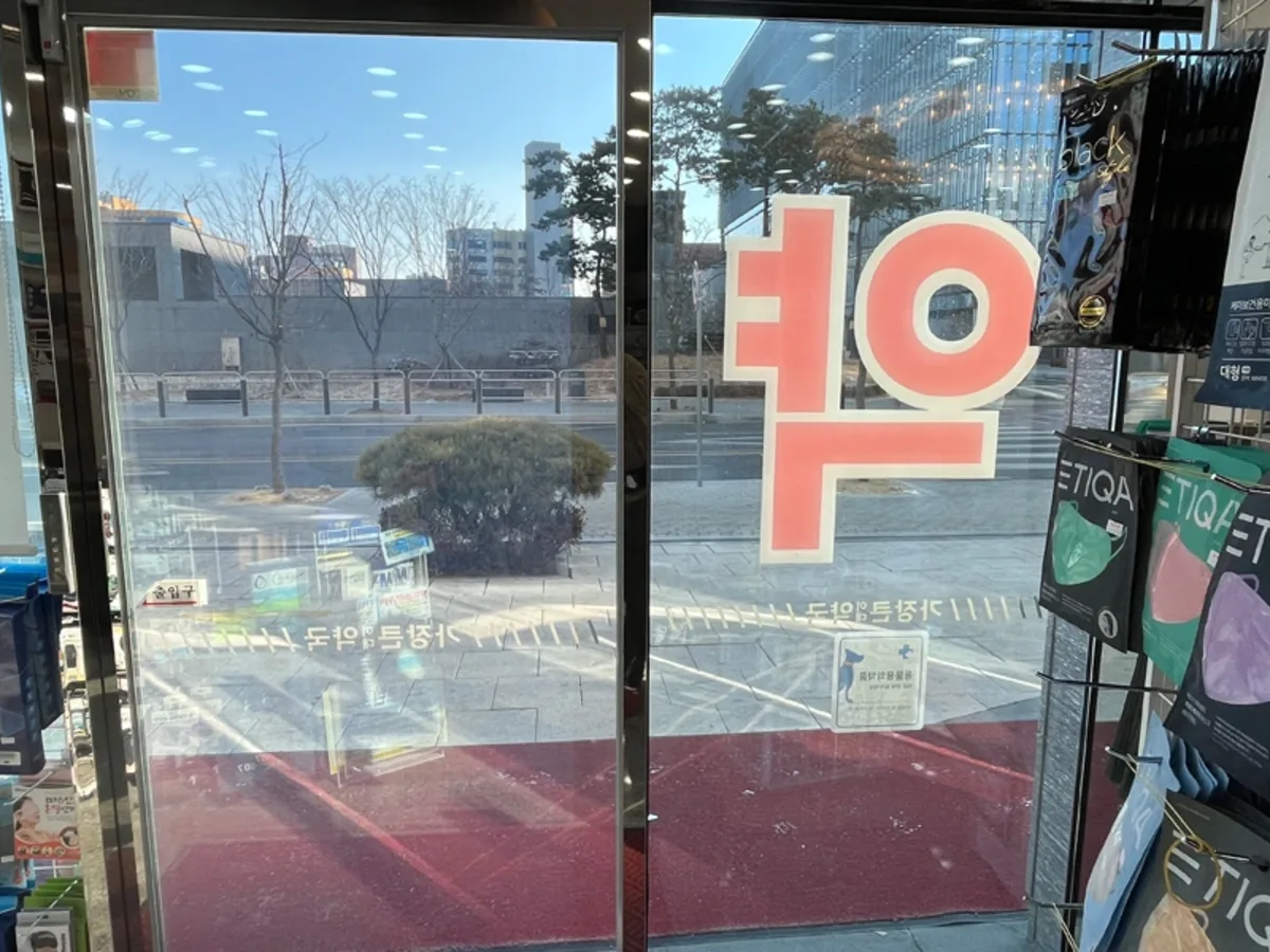 상가 매장 출입문 유리에 거리 풍경이 비치는 시공 전 사진