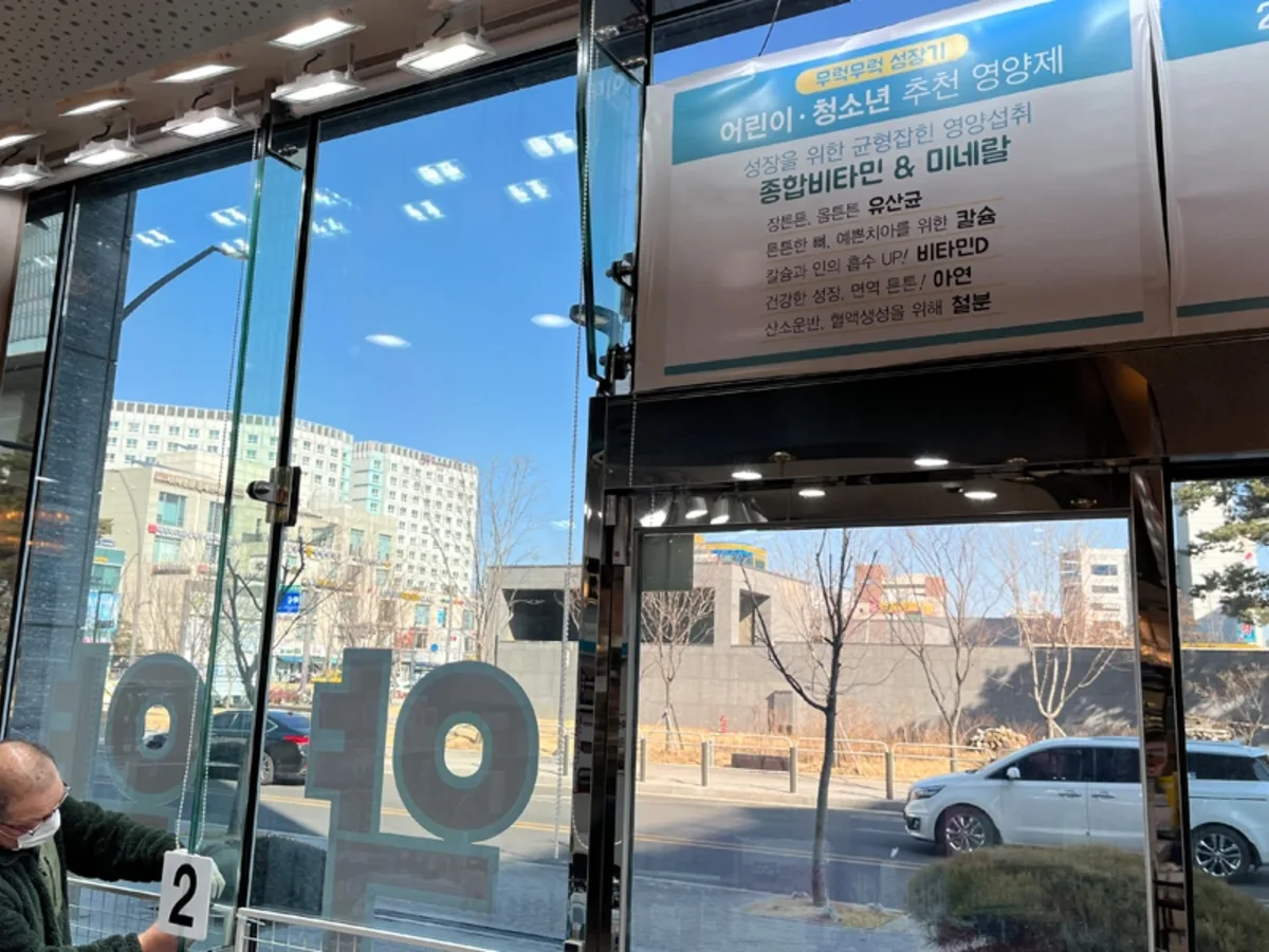 상가 내부 진열대 옆 통유리창으로 도로변 풍경이 보이는 사진
