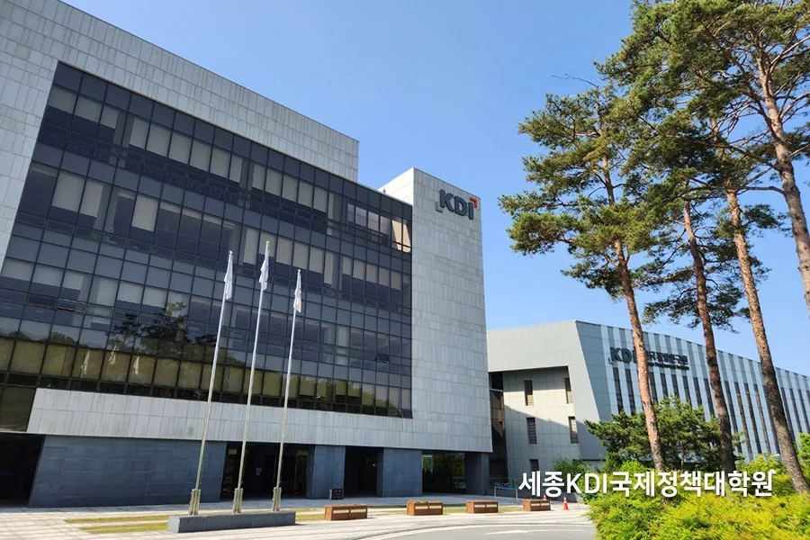 숲을 배경으로 한 대학원 연구동 건물 외벽, 태극기가 걸린 사진